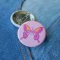 Preview: Ansteckbutton Schmetterling rosa auf Jeans mit Rückseite